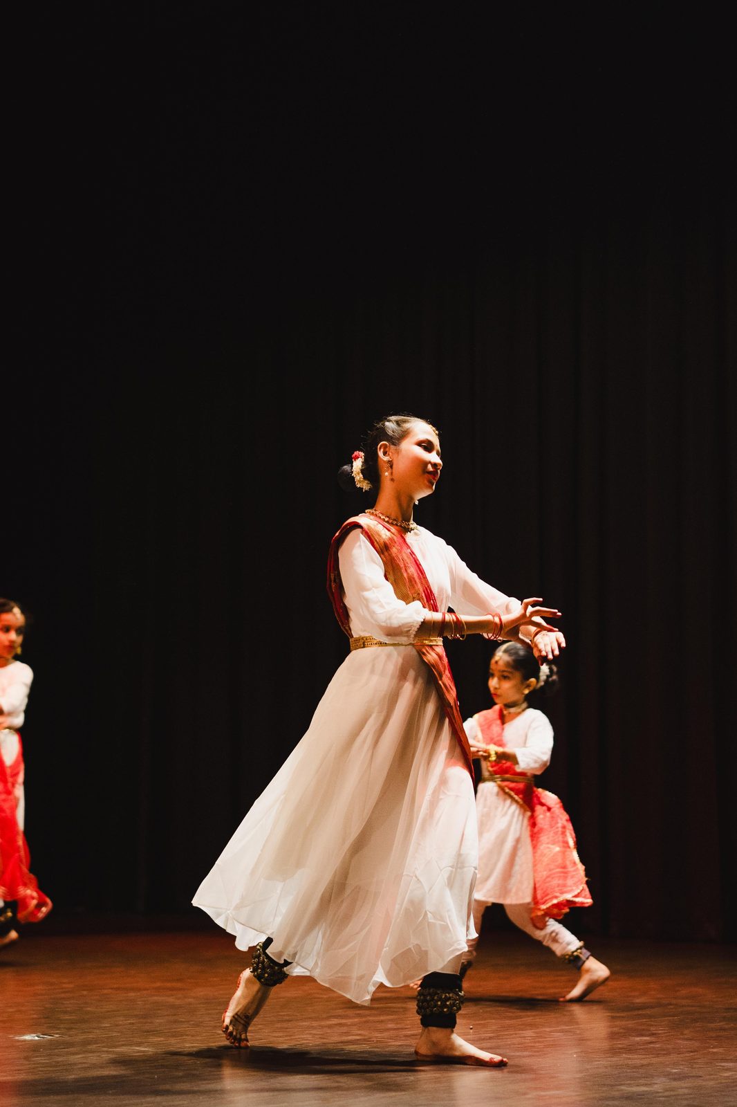 Older and younger student performing together on stage
