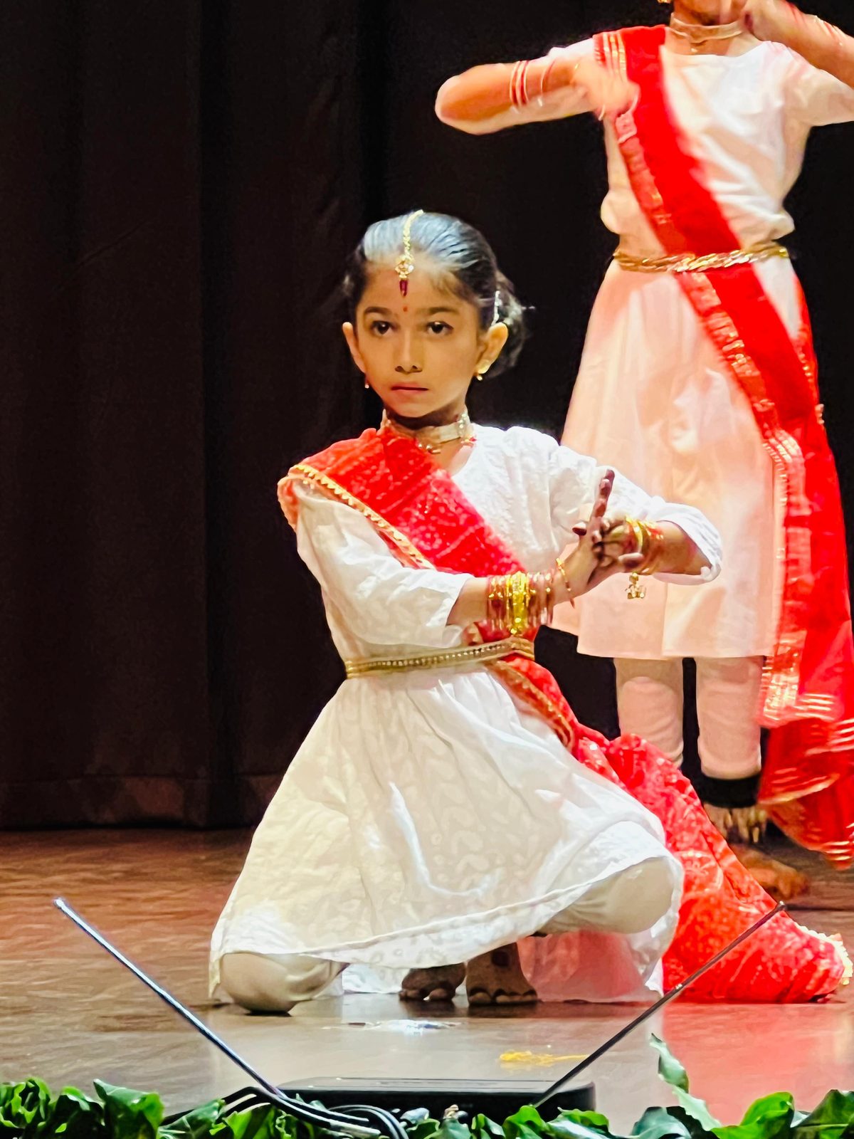 Junior student performing a kneeling Kathak pose
