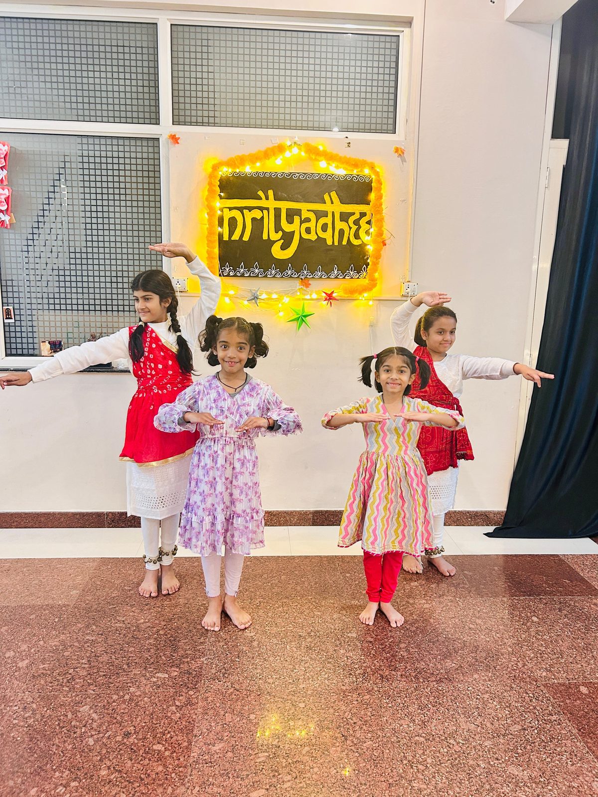 Junior students under the Nrityadhee backdrop