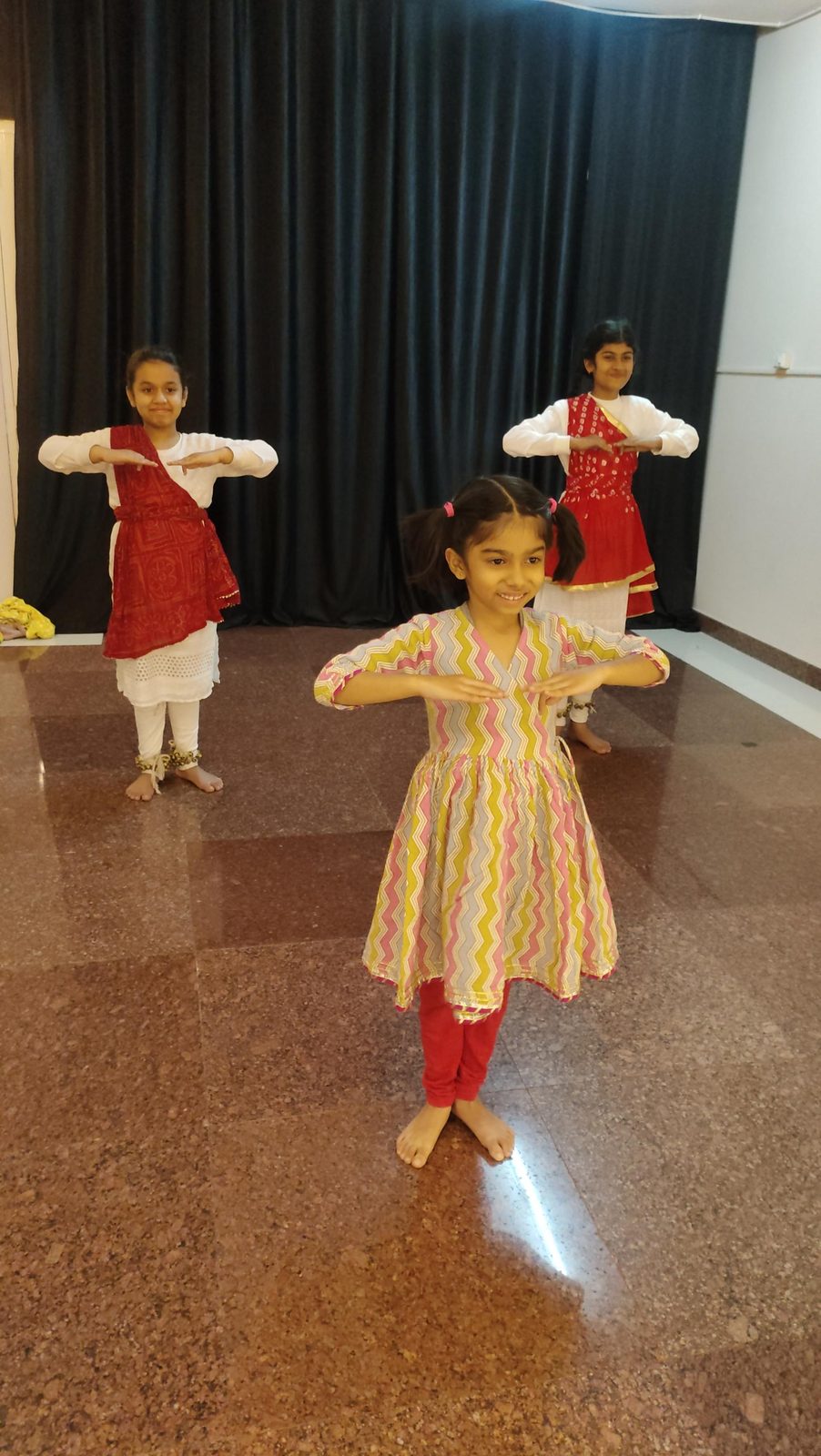 Three young students practicing a Kathak mudra together