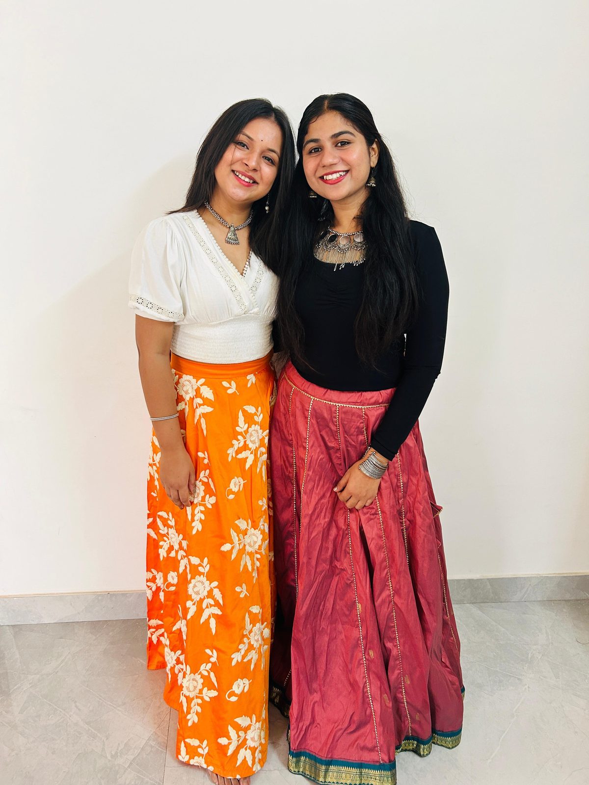 Two senior students in lehengas backstage